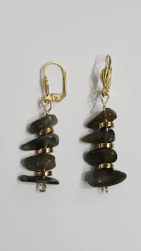 a pair of black labradorite earrings on a white surface