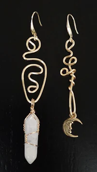 two gold plated earrings with a white quartz stone
